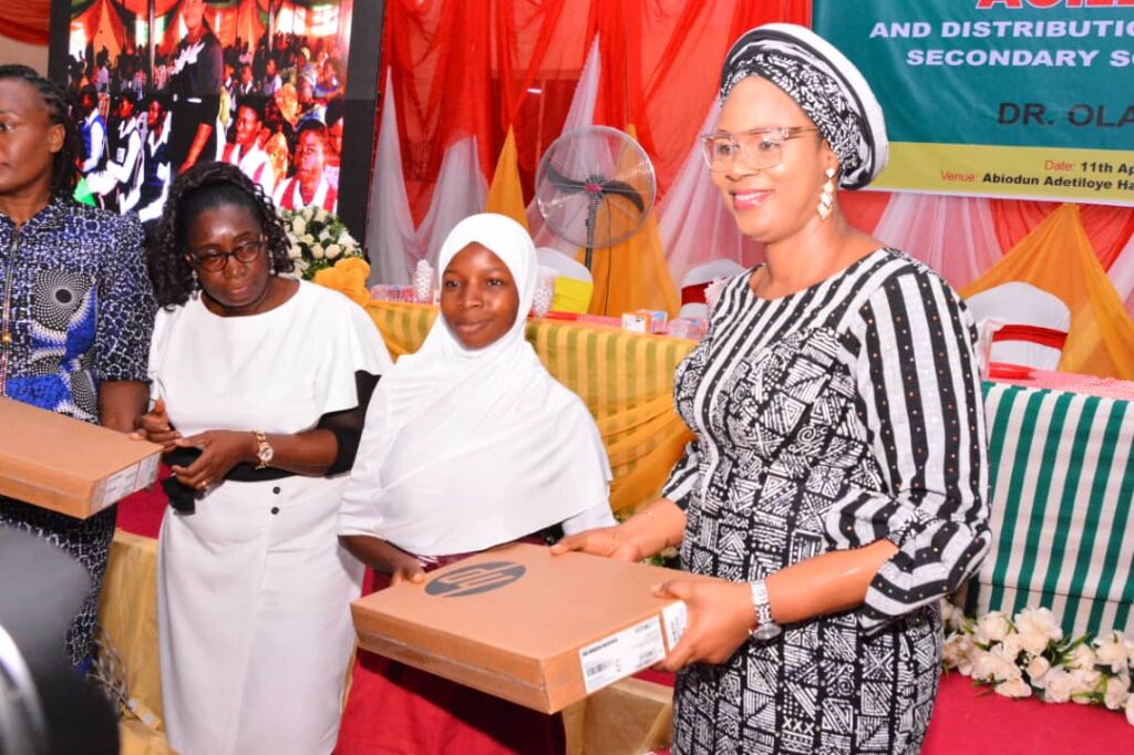 Wife of Ekiti State Governor, Olayemi Oyebanji presenting laptop to students