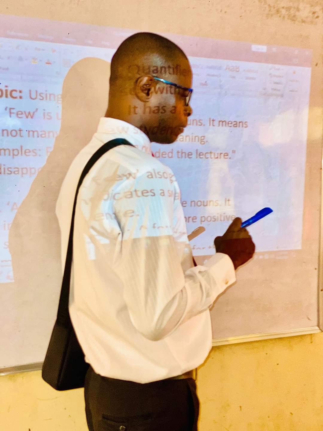 A classroom teacher using a projector in class.